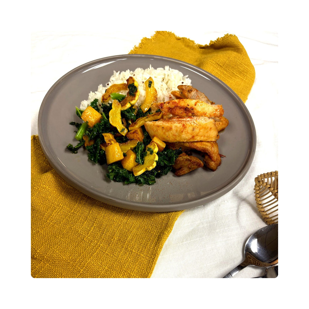 Pimentón chicken thigh with butternut squash, kale and quinoa rice on a mustard napkin